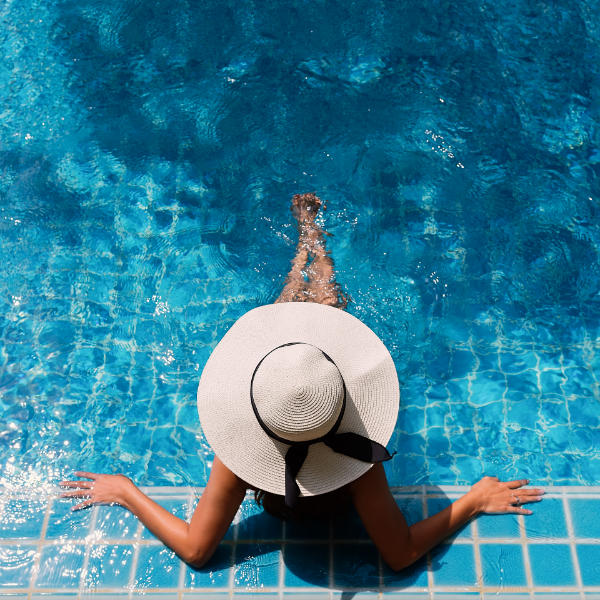 Žena v bazénu s kloboukem